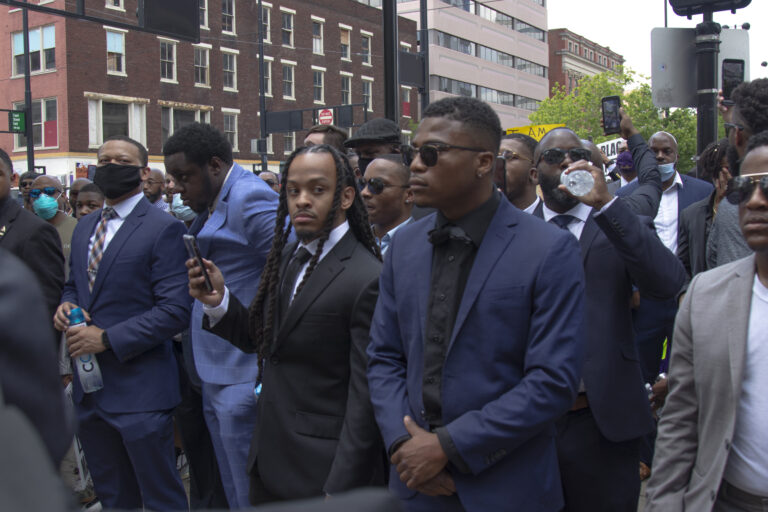 Group shot of Black men dressed in suits standing proud at the George Floyd protest